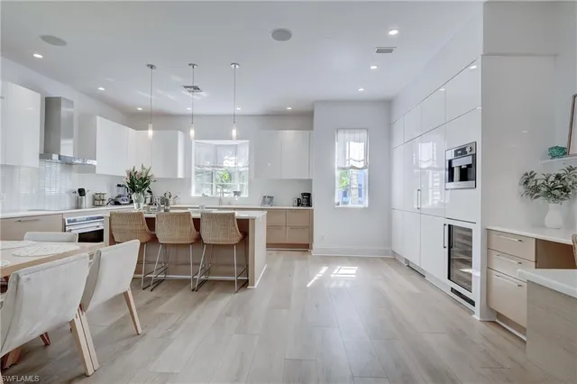a kitchen with stainless steel appliances kitchen island wooden floors and white cabinets