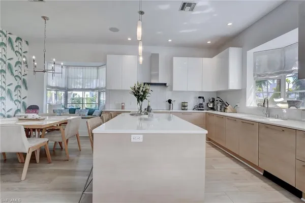 a large white kitchen with a table and chairs