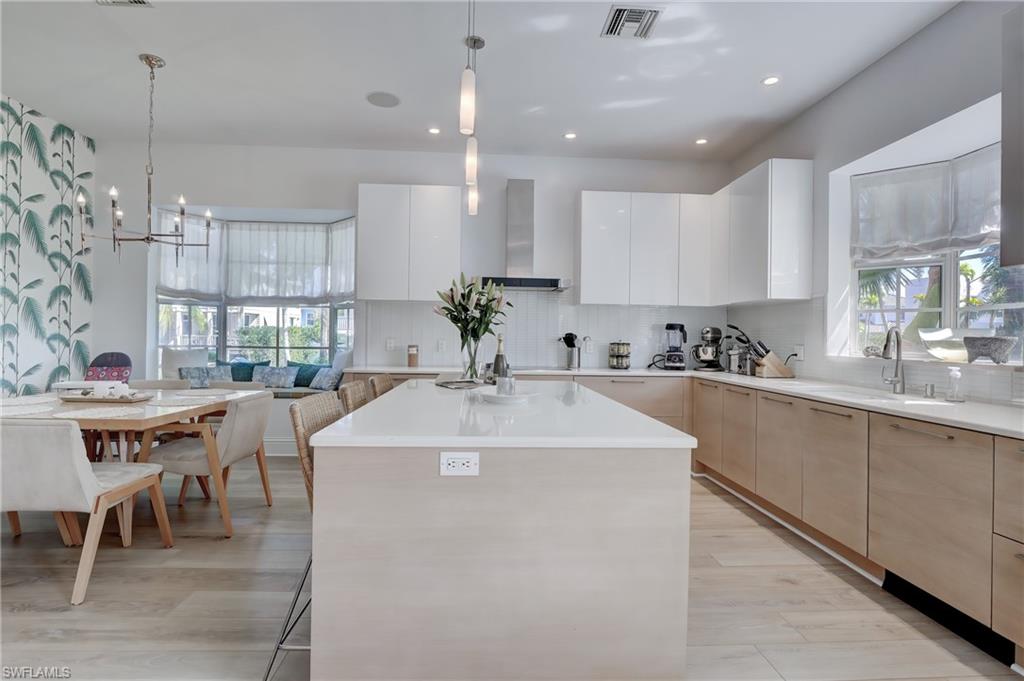 687 9th Avenue South Naples, FL 34102 - Photo 20 of 39 a large white kitchen with a table and chairs