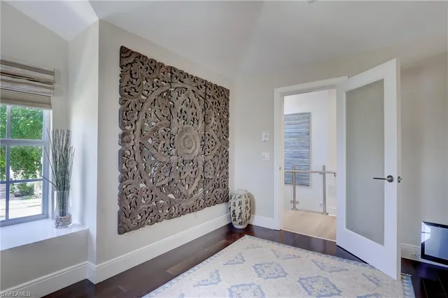 a view of a hallway with wooden floor and furniture