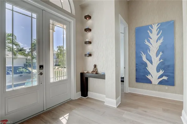 a view of a hallway with wooden floor and windows