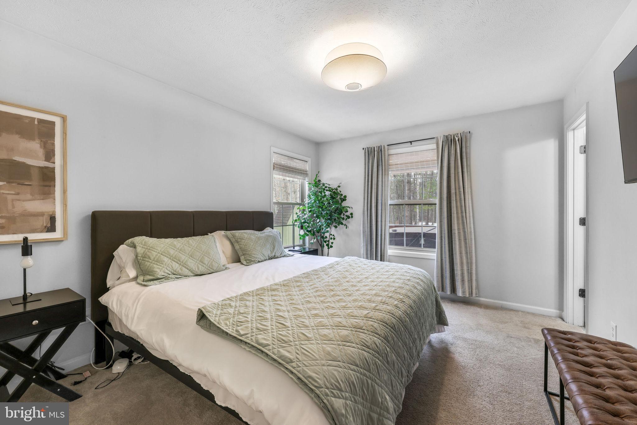 323 Palmer Road Basye, VA 22810 - Photo 15 of 30 a bedroom with a large bed and a chandelier