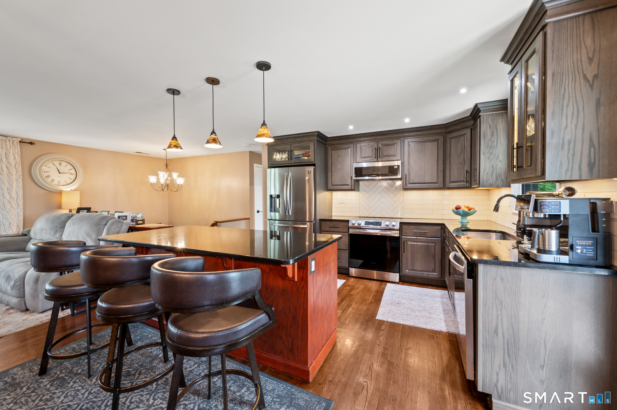 201 Ridge Crest Circle Wethersfield, CT 06109 - Photo 2 of 35 a kitchen with stainless steel appliances granite countertop a stove top oven a sink a dining table and chairs with wooden floor