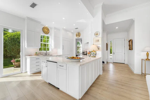 a large white kitchen with a large window