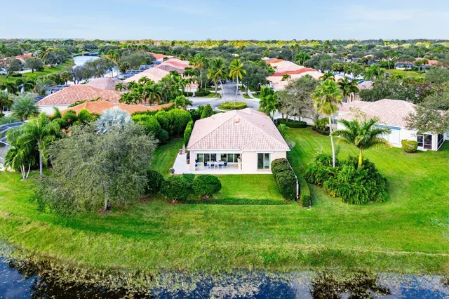 an aerial view of a house with a garden and lake view