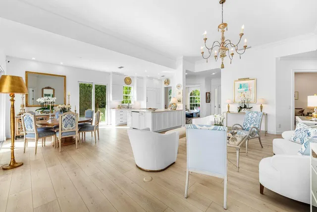 a living room with couches a dining table and chairs with wooden floor
