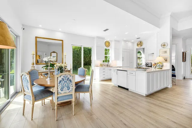 a dining room with furniture a chandelier and wooden floor