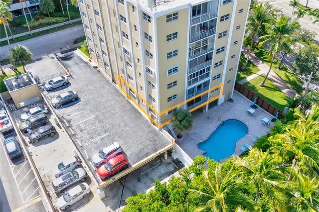 an aerial view of a multi story residential apartment building with a yard