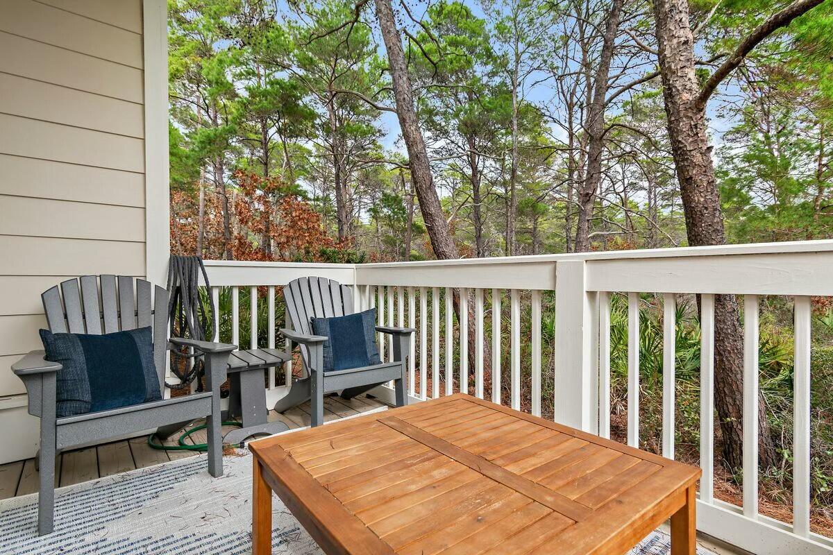 58 East Milestone Dr Inlet Beach, Unit B Inlet Beach, FL 32461 - Photo 15 of 47 a balcony with wooden floor table and chairs