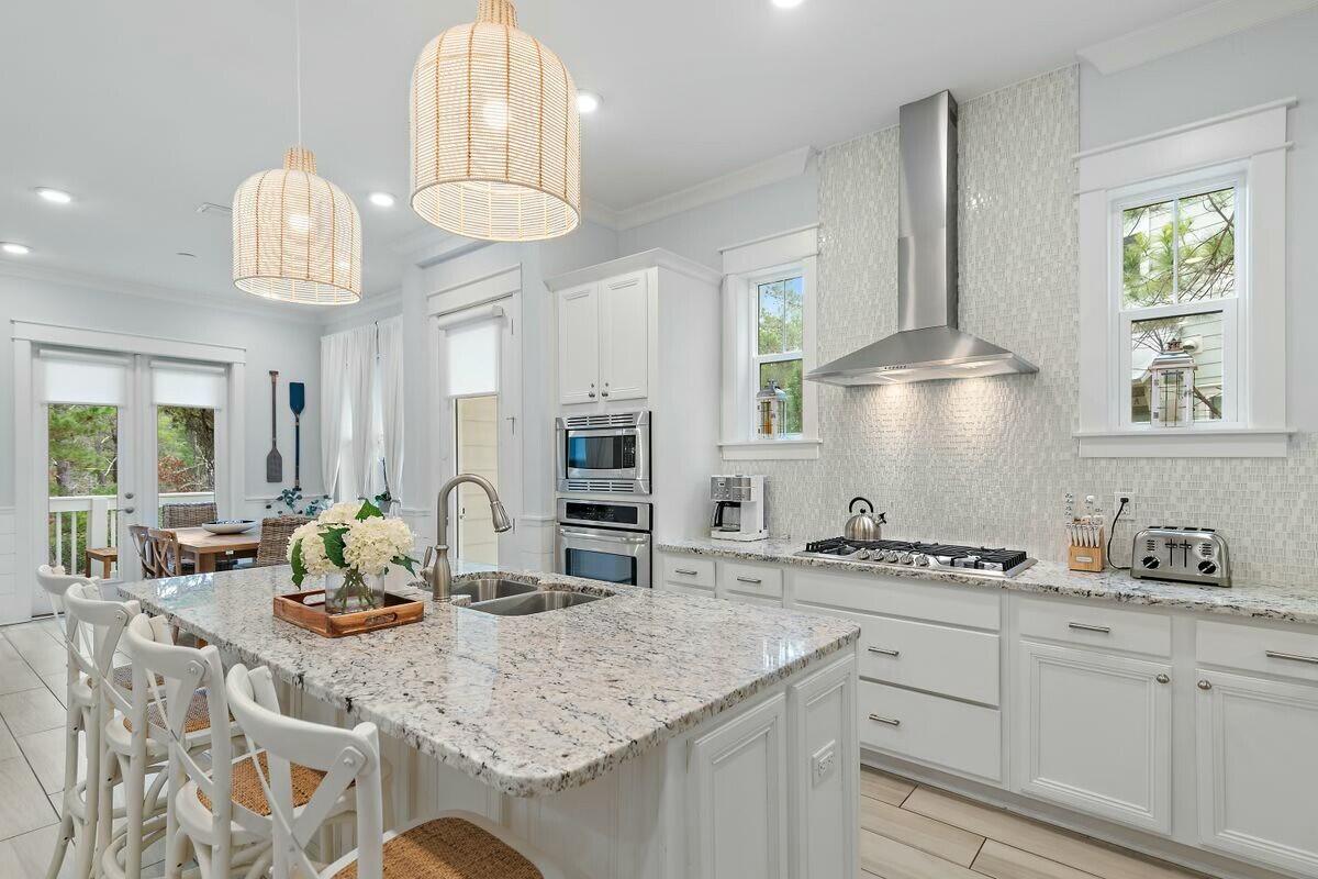 58 East Milestone Dr Inlet Beach, Unit B Inlet Beach, FL 32461 - Photo 2 of 47 a kitchen with stainless steel appliances granite countertop a sink a stove and a wooden floors