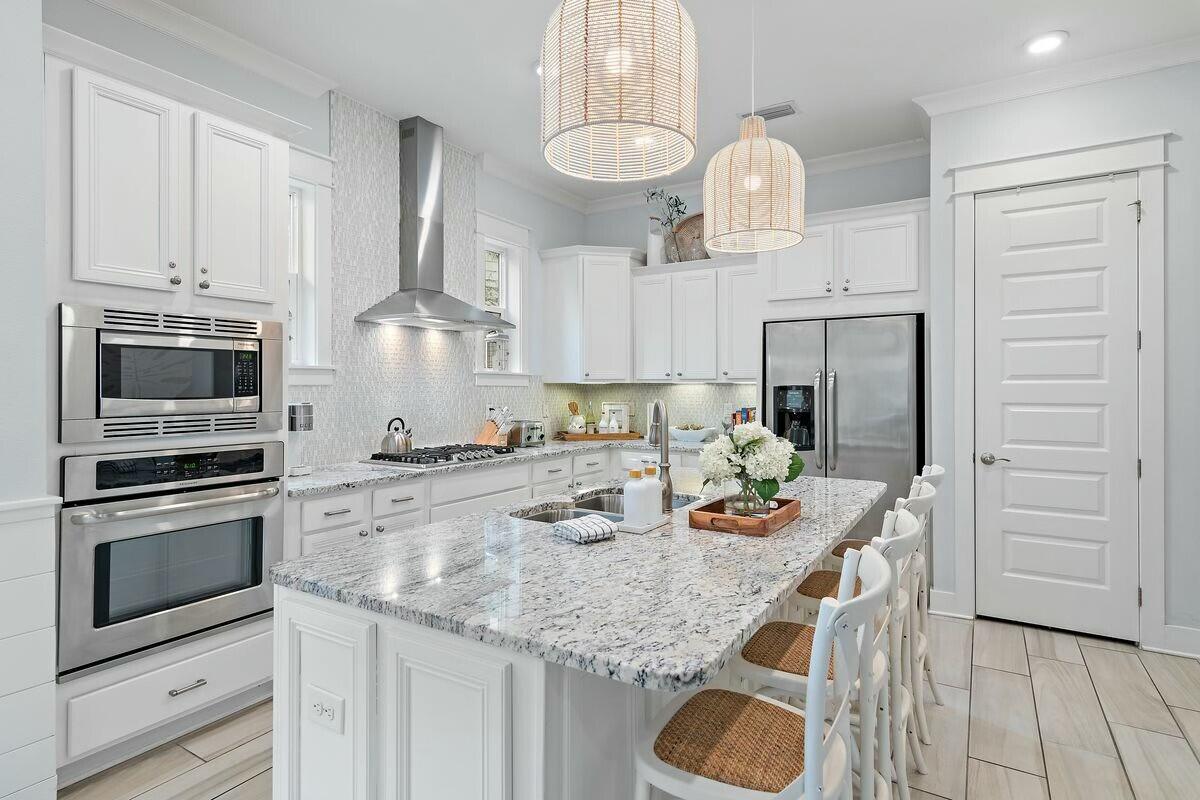 58 East Milestone Dr Inlet Beach, Unit B Inlet Beach, FL 32461 - Photo 8 of 47 a kitchen with stainless steel appliances granite countertop a sink dishwasher a stove and a refrigerator with wooden floor