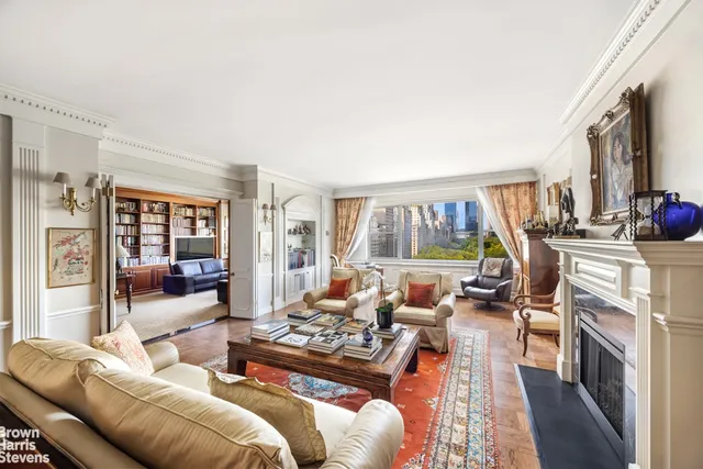 a living room with furniture fireplace and a large window