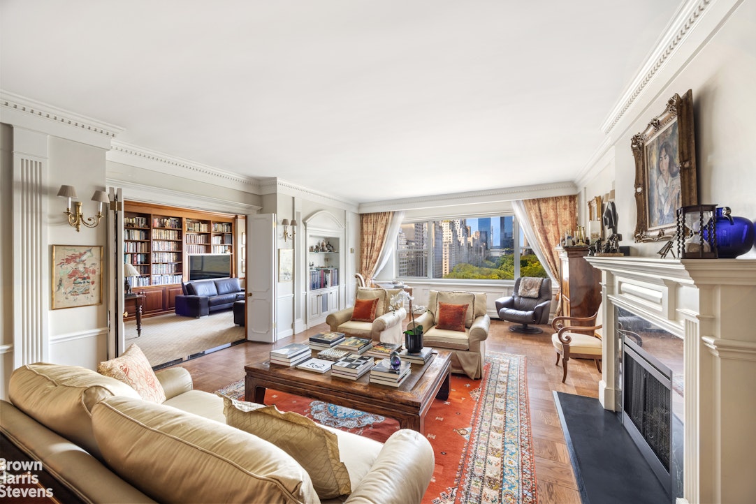 a living room with furniture fireplace and a large window