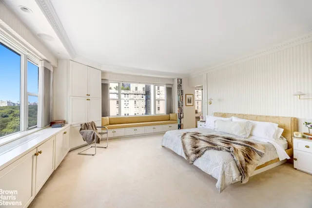 a bed sitting in a bedroom next to a large window with a large window