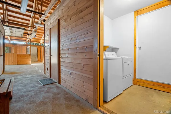 a living room with furniture large windows and wooden floor