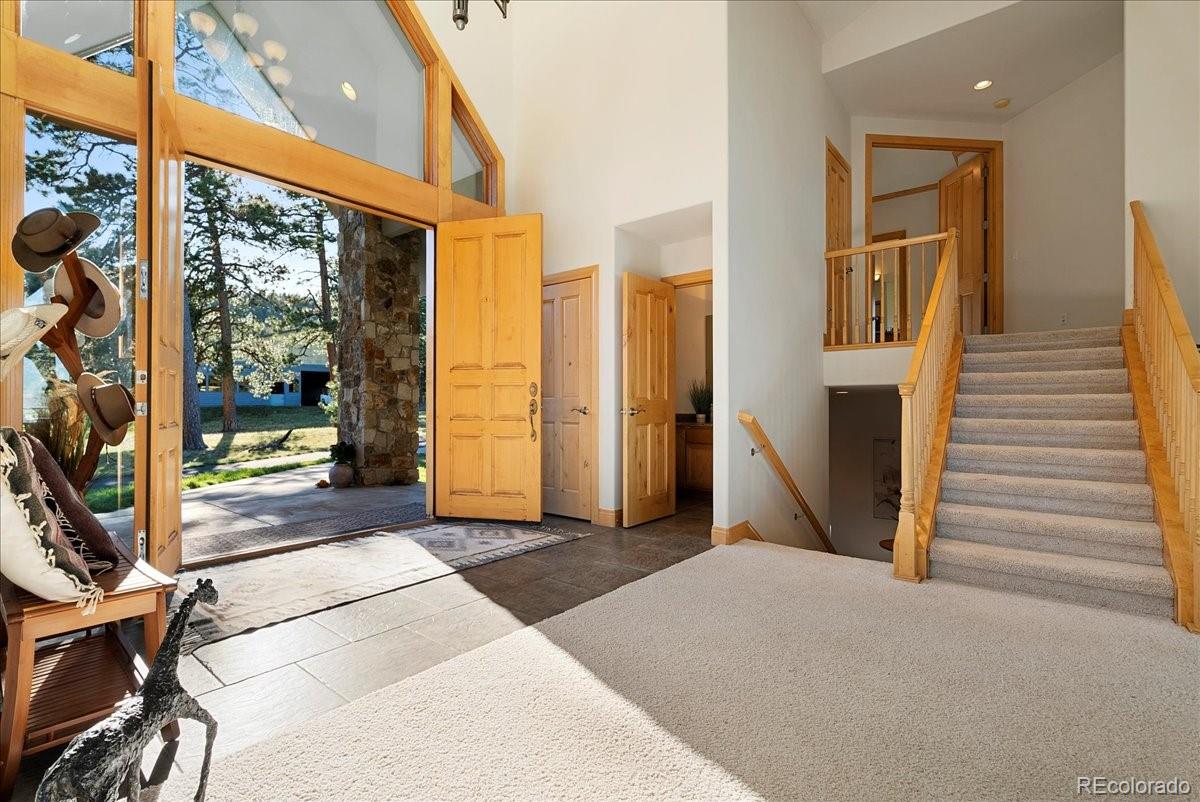 20682 Falcon Wing Road Indian Hills, CO 80454 - Photo 17 of 50 a view of a hallway with wooden floor and a glass door