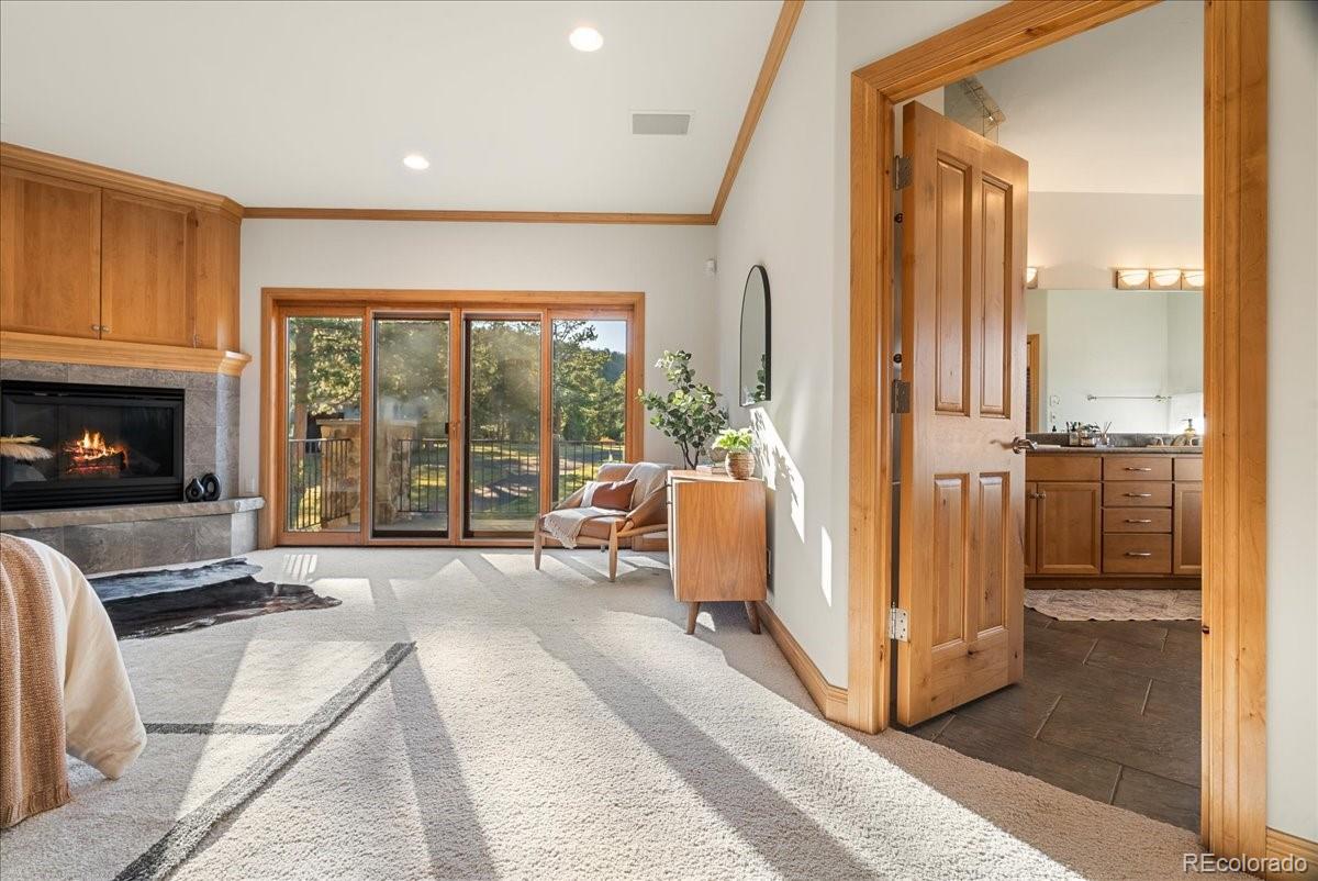 20682 Falcon Wing Road Indian Hills, CO 80454 - Photo 29 of 45 a bedroom with furniture and a fireplace