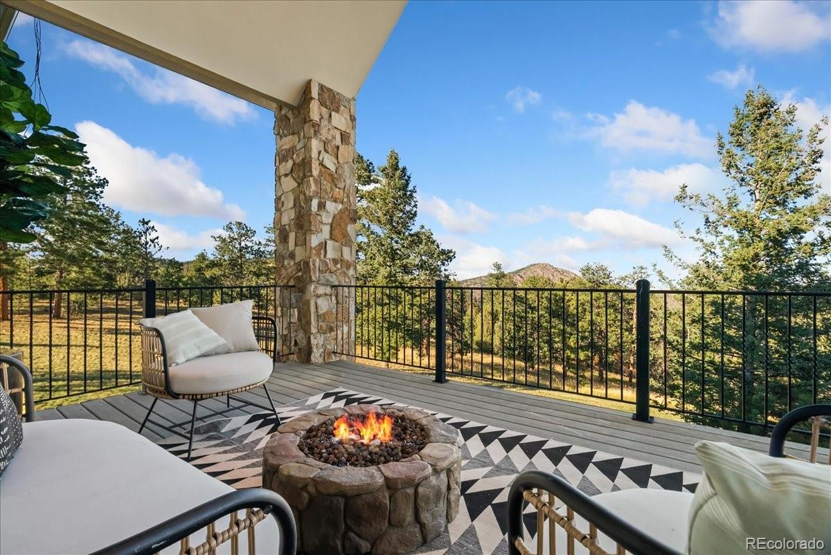 20682 Falcon Wing Road Indian Hills, CO 80454 - Photo 3 of 50 a view of a balcony with two chairs and a wooden fence