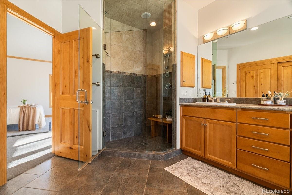 20682 Falcon Wing Road Indian Hills, CO 80454 - Photo 32 of 45 a bathroom with a shower sink and mirror