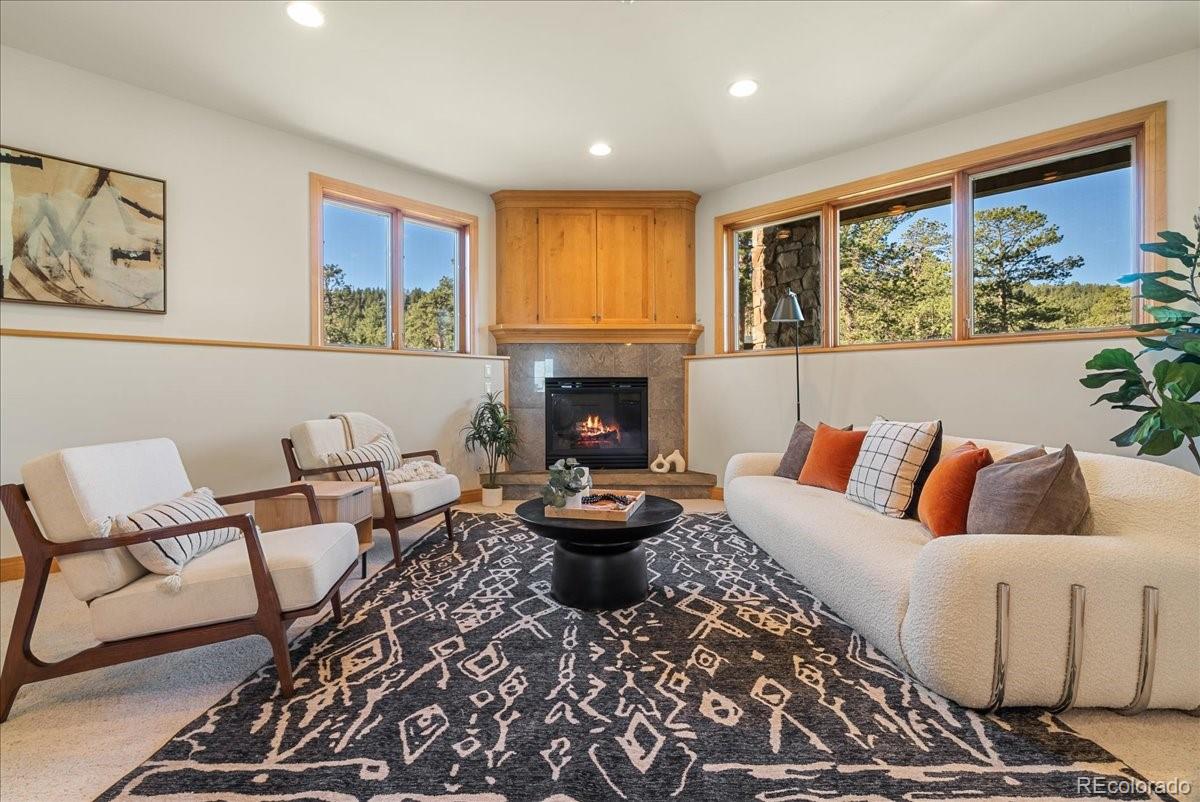 20682 Falcon Wing Road Indian Hills, CO 80454 - Photo 37 of 45 a living room with fireplace furniture and a large window