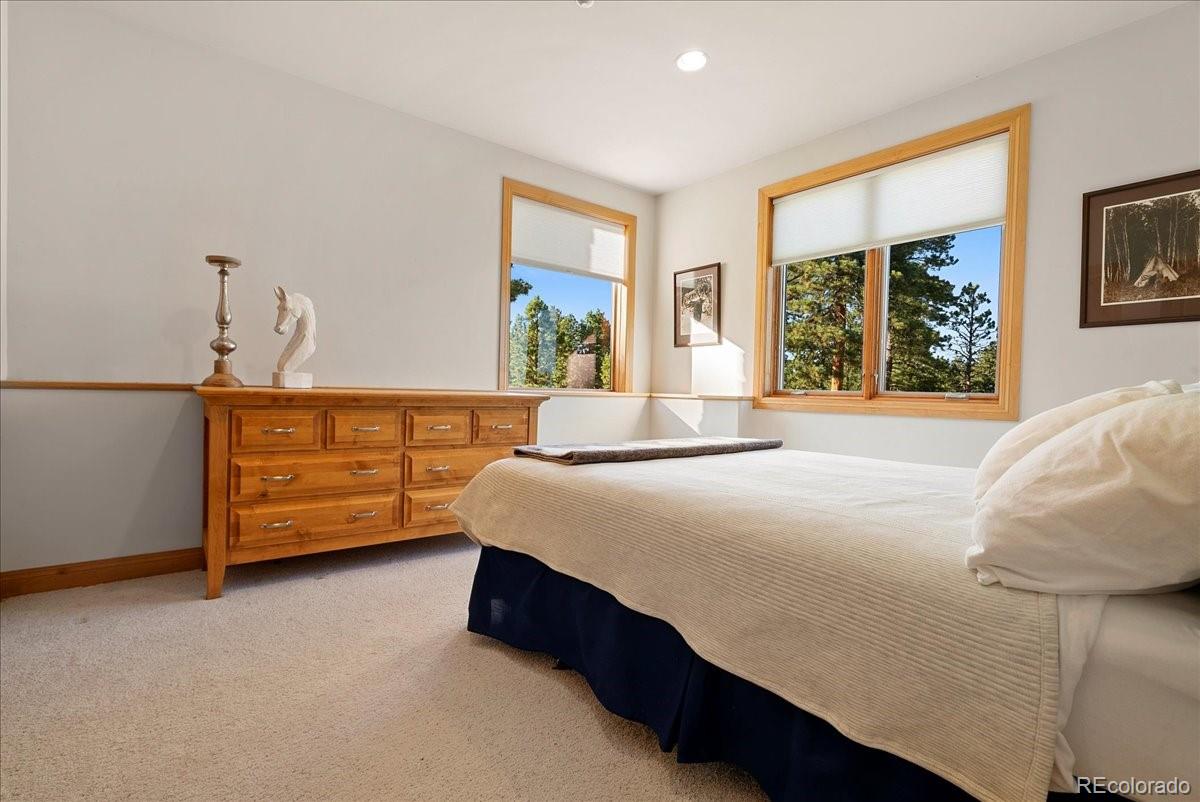 20682 Falcon Wing Road Indian Hills, CO 80454 - Photo 39 of 45 a bedroom with a bed dresser and a window