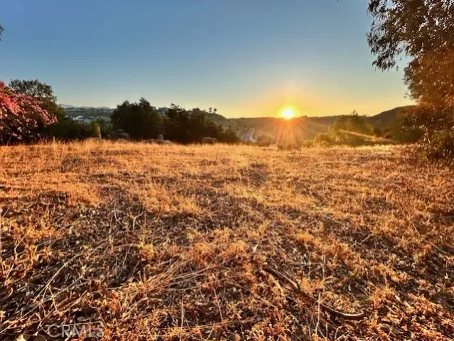 a view of mountain with sunset in background