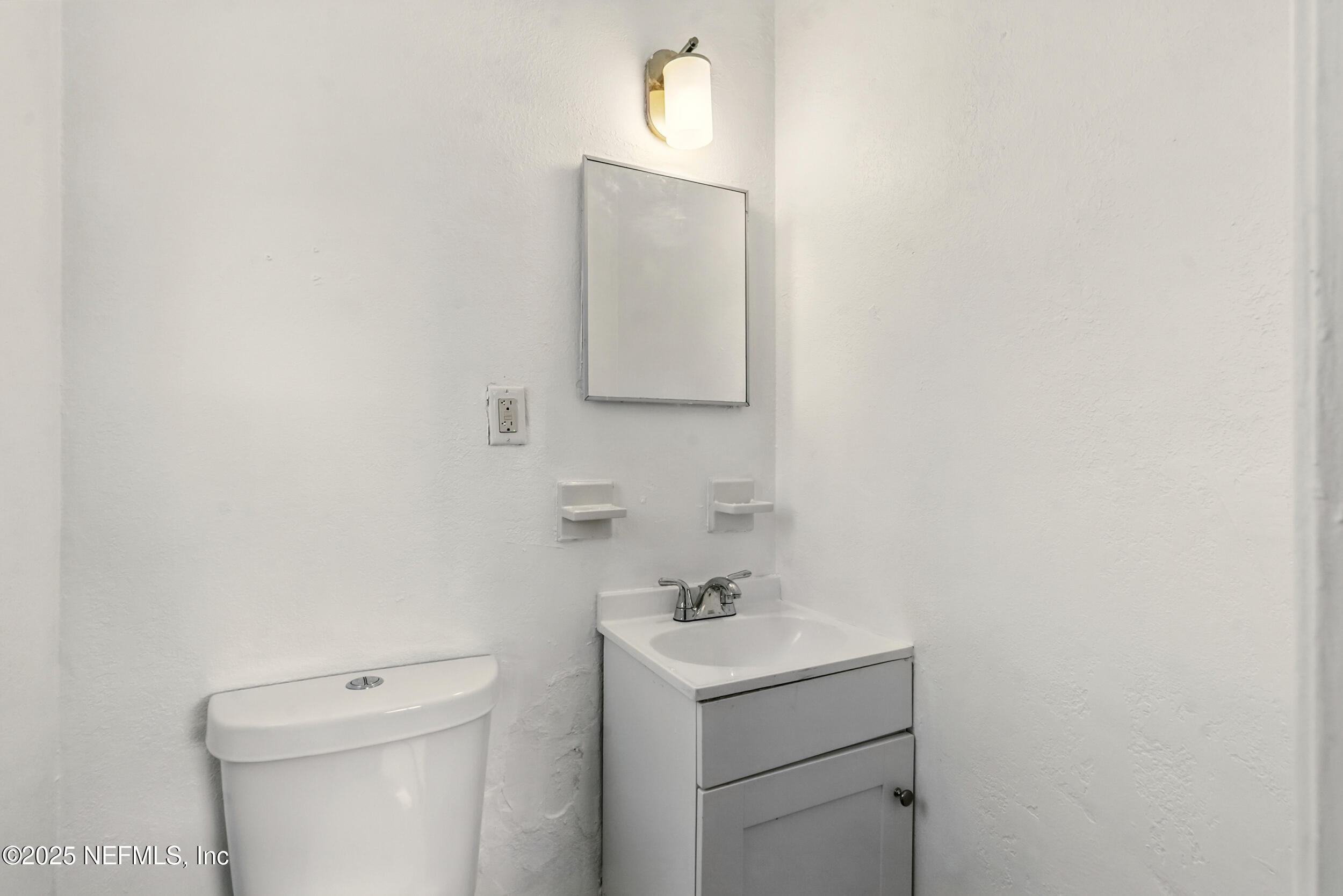 7120 Merrill Road Jacksonville, FL 32211 - Photo 29 of 60 a bathroom with a toilet sink vanity and mirror