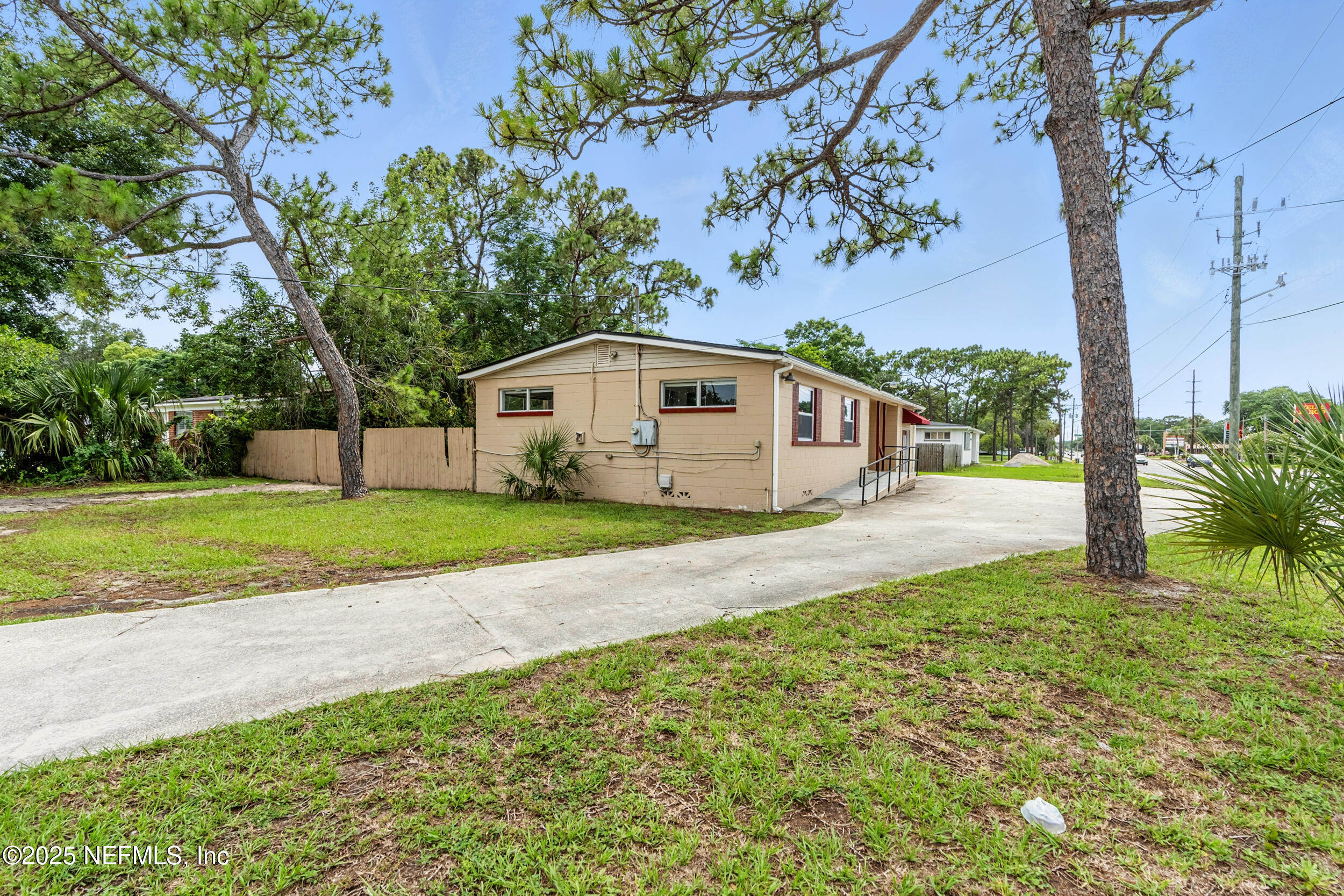 7120 Merrill Road Jacksonville, FL 32211 - Photo 7 of 60 a white house with a big yard plants and large trees
