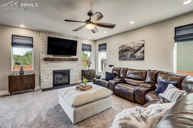 2085 Reed Grass Way Colorado Springs, CO 80915 - Photo 8 of 25 Living room has high-end carpet; upgraded gas fireplace (35,000 BTU) with floor-to-ceiling stone surround & wood mantel; recessed lighting; and roman shades.