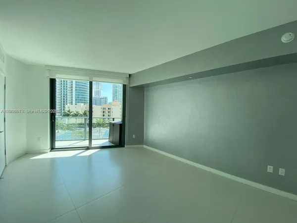 an empty room with wooden floor and sliding door