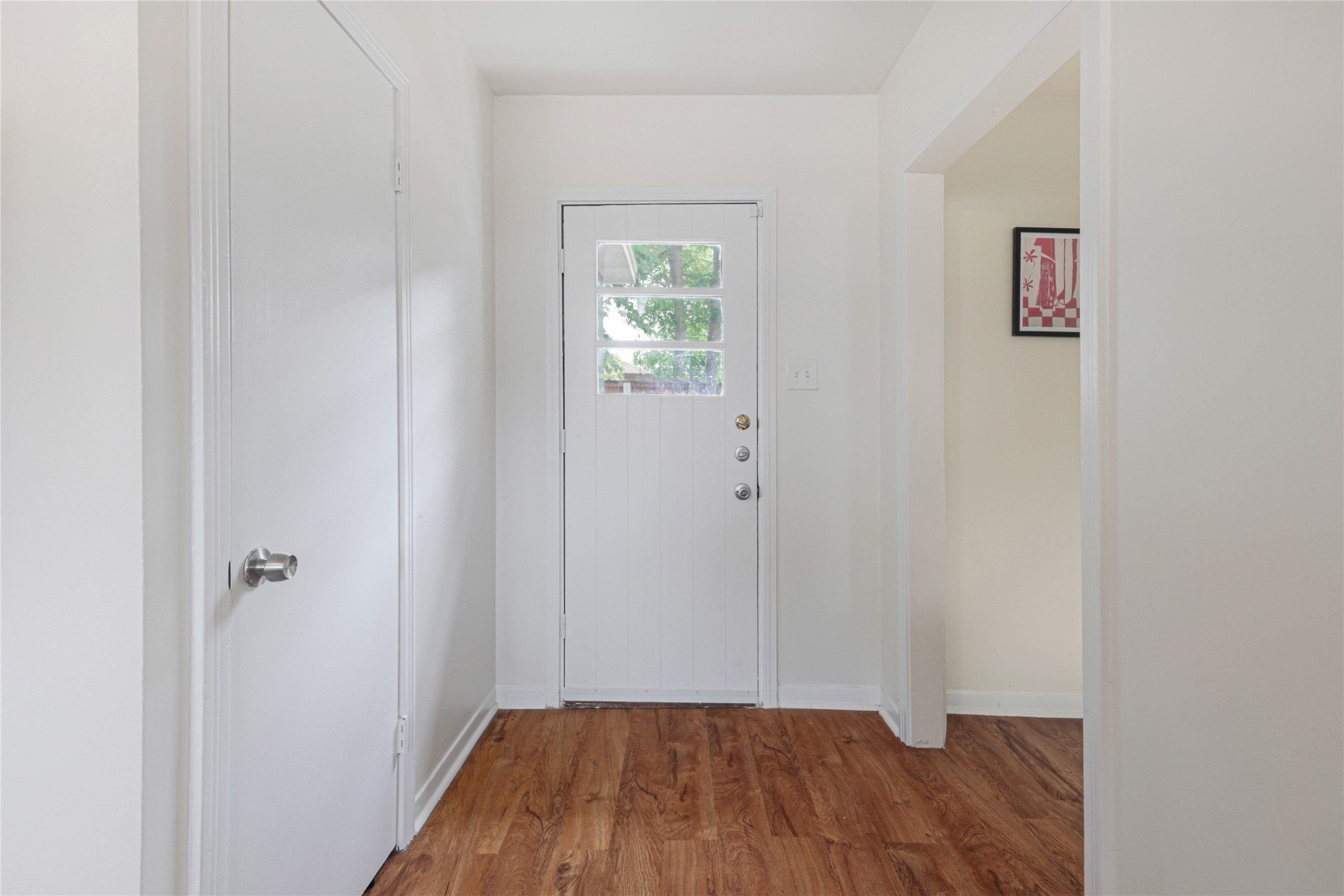 4607 Evans Avenue, Unit B Austin, TX 78751 - Photo 5 of 34 Entryway featuring wood-finish flooring, a white paneled door with glass inserts, and a closet with a brushed nickel doorknob