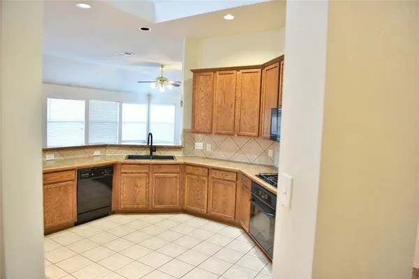 a kitchen with stainless steel appliances granite countertop a sink and a stove