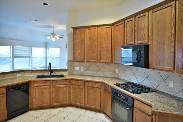 a kitchen with a sink stove top oven and cabinets