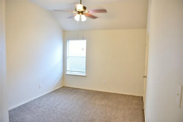 an empty room with a window and a fan