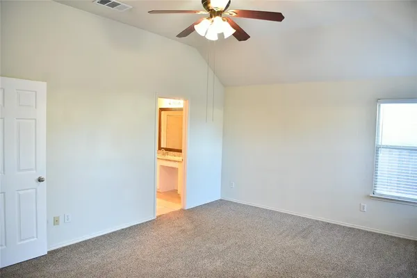 an empty room with windows and fan