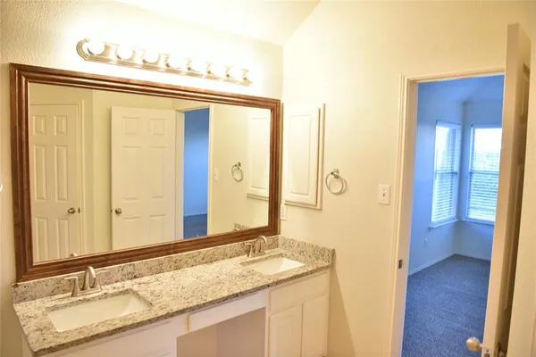 a bathroom with a granite countertop sink and a mirror