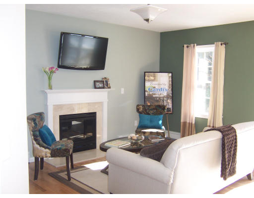 Lot 101 Lot Drive Rochester, MA 02770 - Photo 2 of 5 a living room with furniture a flat screen tv and a fireplace