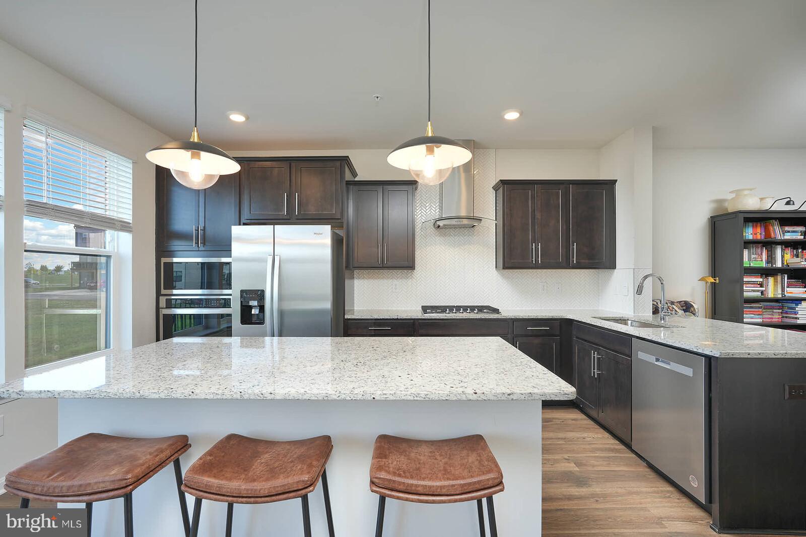 869 Amity Street Frederick, MD 21701 - Photo 13 of 48 a kitchen with stainless steel appliances granite countertop a sink a stove a dining table and chairs