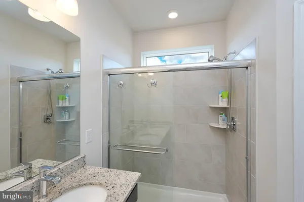a bathroom with a granite countertop bathtub shower and toilet