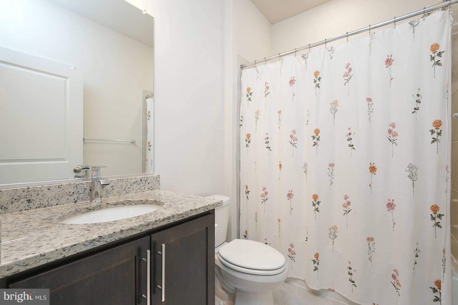 869 Amity Street Frederick, MD 21701 - Photo 34 of 48 a bathroom with a granite countertop sink toilet and a mirror