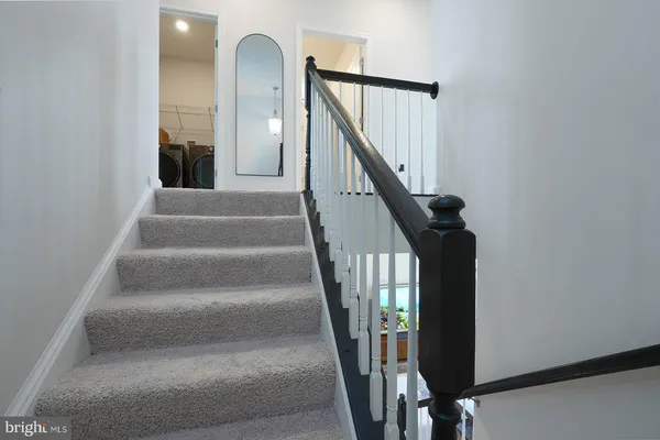 a view of staircase with white walls and a window