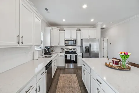 a kitchen with kitchen island granite countertop lots of counter top space and refrigerator