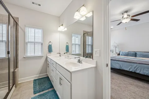 a bathroom with a double vanity sink mirror and bathtub