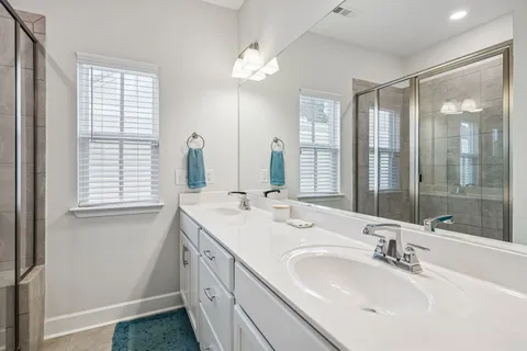 a bathroom with double vanity sinks and a mirror