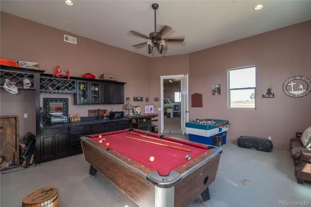 a room with pool table and windows