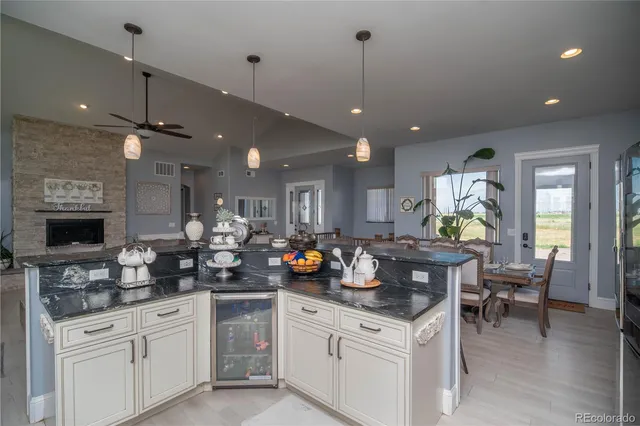 a kitchen with a sink a refrigerator and chairs