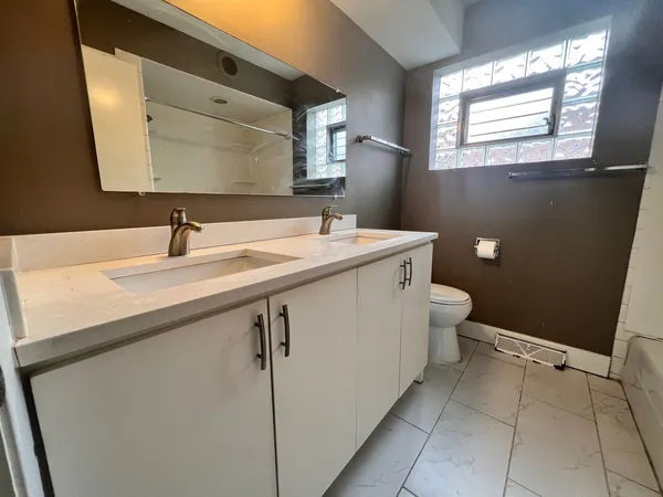 a bathroom with a sink a toilet and mirror