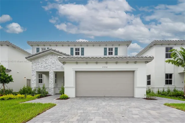 a front view of a house with a garden and garage