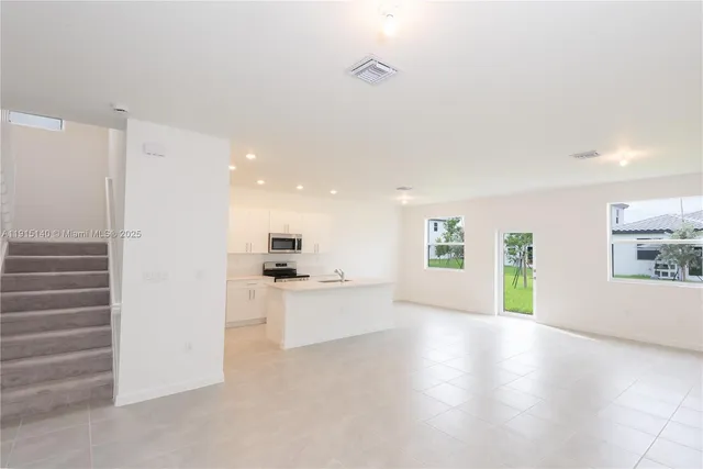 a view of a kitchen with a sink and a refrigerator