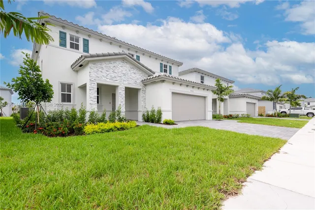 a front view of a house with a yard and garage